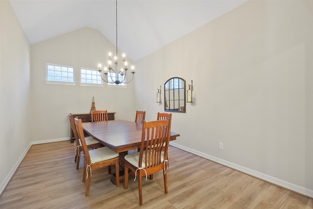 dining space featuring light hardwood / wood-style floors, high vaulted ceiling, and a chandelier