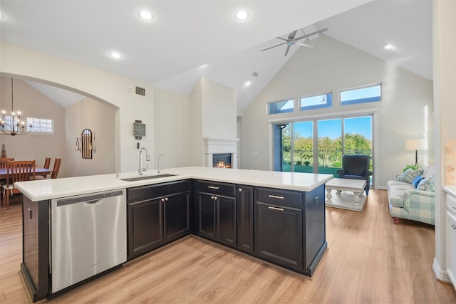 kitchen with dishwasher, high vaulted ceiling, ceiling fan with notable chandelier, sink, and light hardwood / wood-style floors