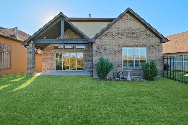 rear view of property with a lawn and a patio