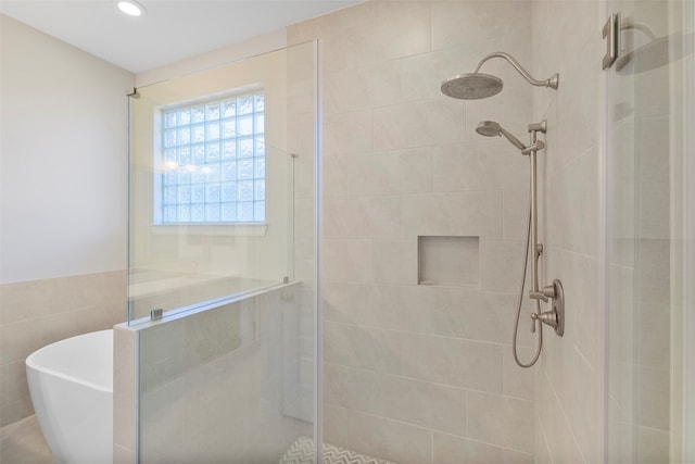 bathroom featuring tile walls and independent shower and bath