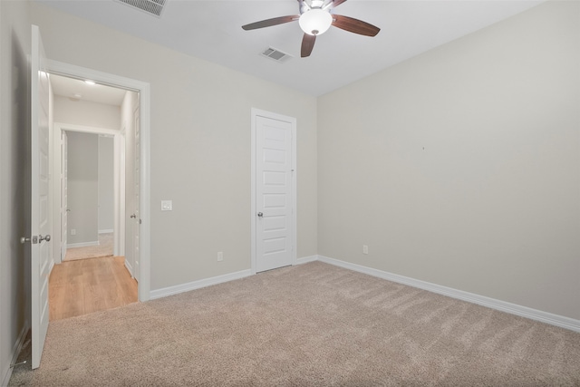 unfurnished bedroom with ceiling fan, light carpet, and a closet