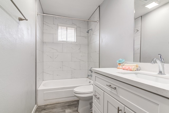 full bathroom featuring toilet, vanity, tiled shower / bath combo, and hardwood / wood-style flooring