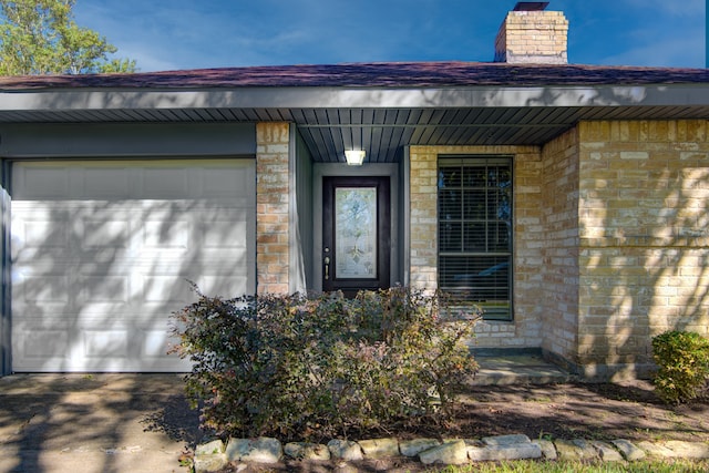 doorway to property featuring covered porch and a garage