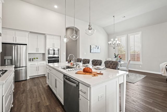 kitchen with a center island with sink, sink, vaulted ceiling, white cabinetry, and stainless steel appliances