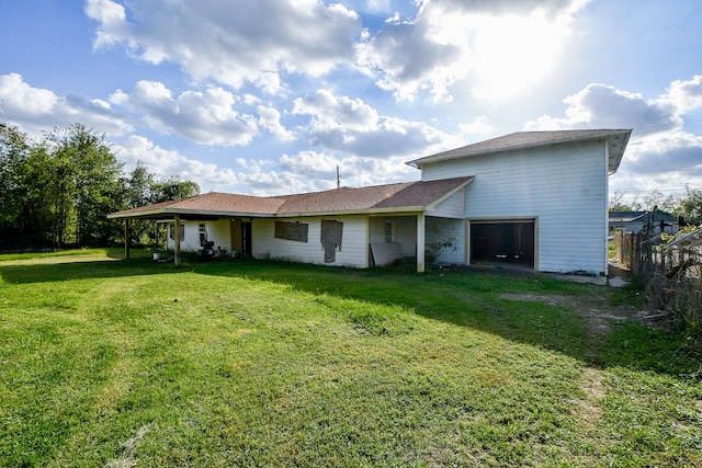 rear view of property with a yard and a garage