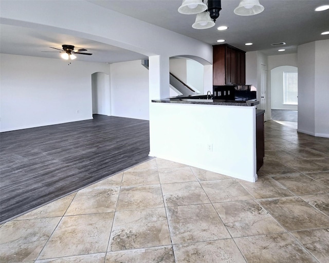 kitchen with dark brown cabinetry, ceiling fan, sink, light hardwood / wood-style flooring, and kitchen peninsula