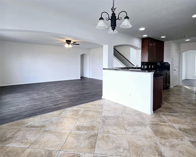 kitchen with light wood-type flooring, dark brown cabinetry, ceiling fan with notable chandelier, sink, and hanging light fixtures