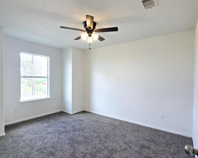 spare room with ceiling fan and dark carpet