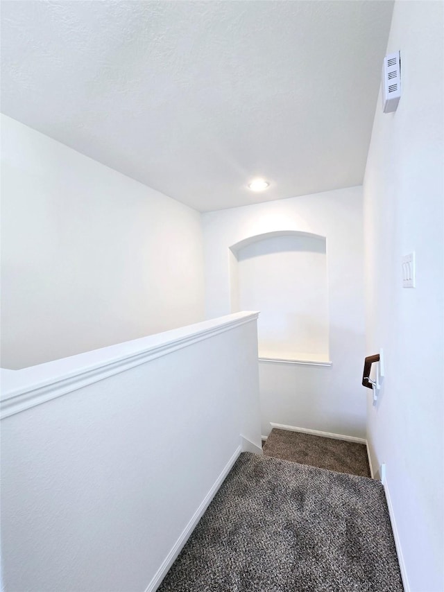 corridor with dark colored carpet