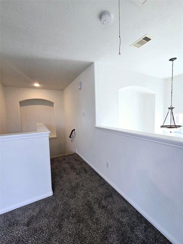 carpeted empty room with a textured ceiling