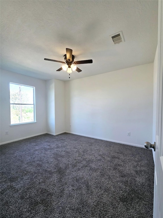 carpeted empty room featuring a textured ceiling and ceiling fan