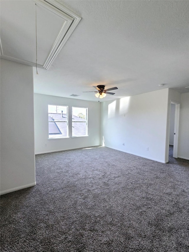 carpeted empty room featuring ceiling fan and a textured ceiling