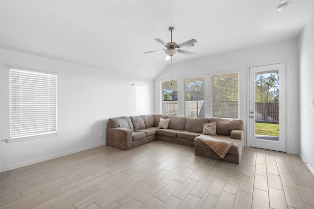 living room with ceiling fan, vaulted ceiling, and light wood-type flooring