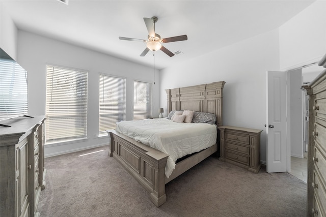 bedroom featuring multiple windows, ceiling fan, and light colored carpet