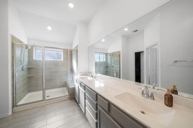 bathroom with a shower with shower door, lofted ceiling, and vanity