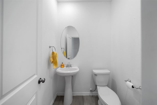 bathroom with hardwood / wood-style floors, toilet, and sink