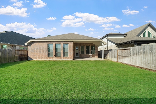 rear view of property with a lawn and a patio