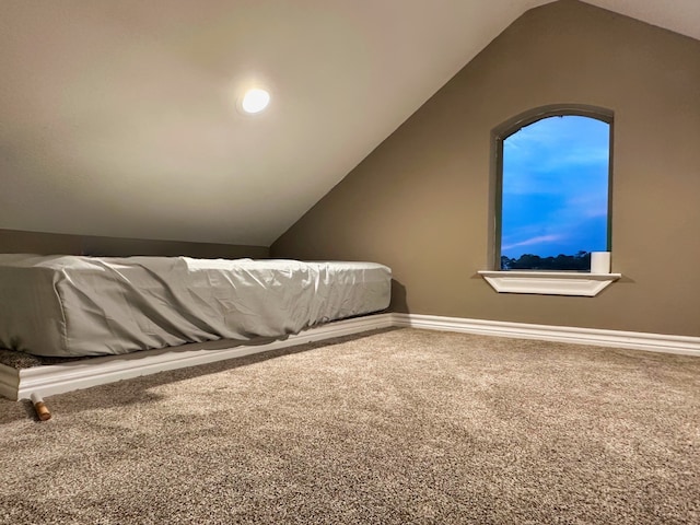 unfurnished bedroom featuring carpet and vaulted ceiling