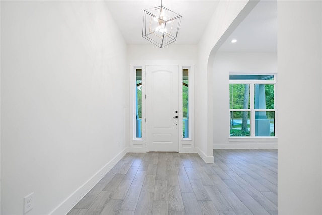 foyer with a notable chandelier and light hardwood / wood-style flooring