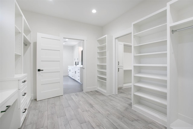 walk in closet with light wood-type flooring