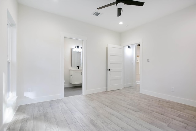 unfurnished bedroom featuring ensuite bathroom, ceiling fan, and light hardwood / wood-style floors