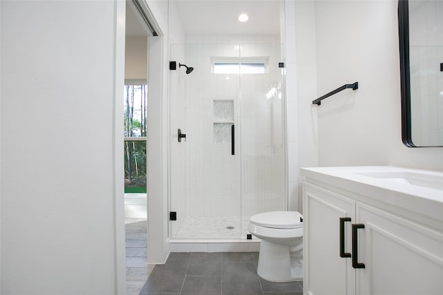 bathroom featuring tile patterned flooring, toilet, a shower with door, and vanity