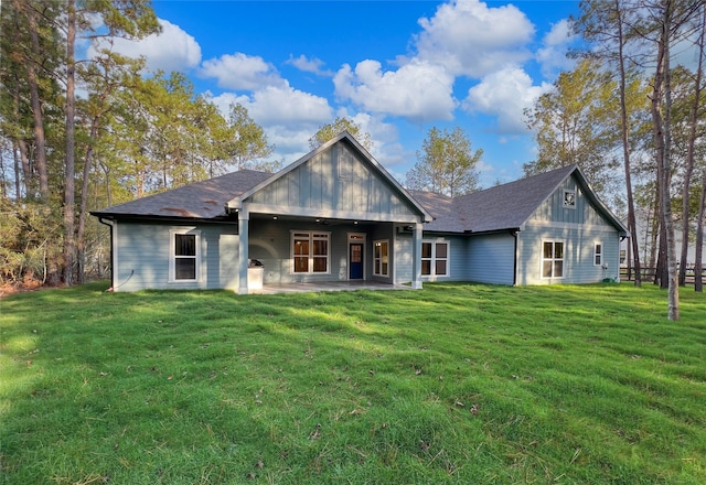 back of house with a patio area and a lawn