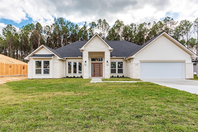 view of front of house with stone siding, a shingled roof, concrete driveway, an attached garage, and a front yard