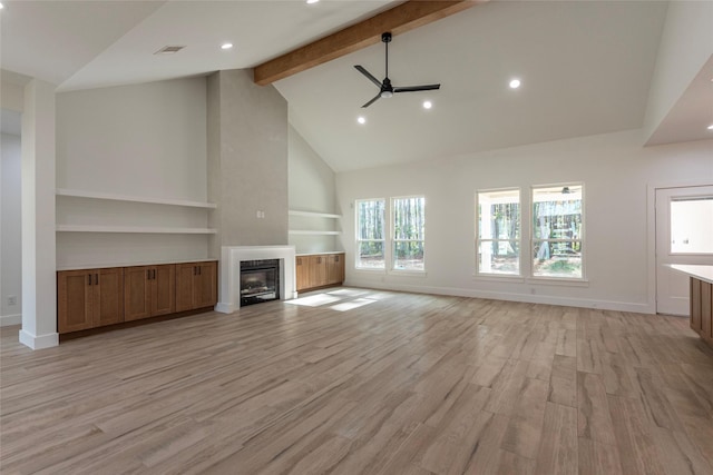 unfurnished living room with beam ceiling, ceiling fan, high vaulted ceiling, and light wood-type flooring