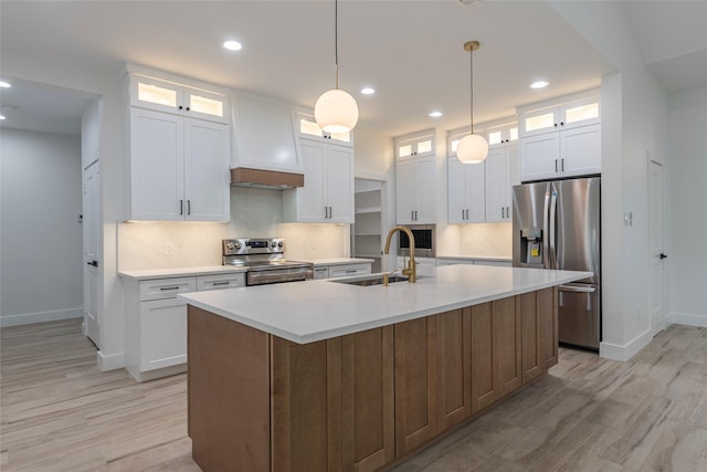 kitchen featuring a center island with sink, sink, white cabinetry, and stainless steel appliances