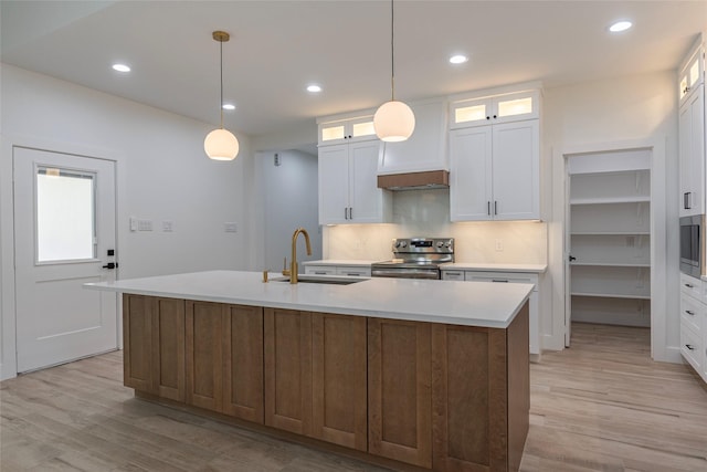 kitchen featuring white cabinetry, sink, a center island with sink, and appliances with stainless steel finishes