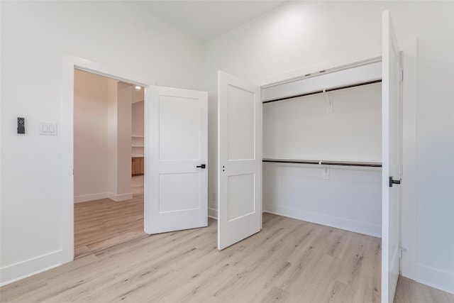 unfurnished bedroom with light hardwood / wood-style floors and a closet