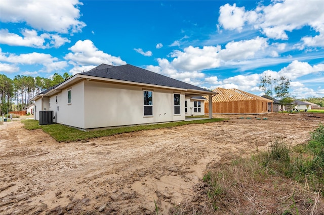 rear view of property with central AC