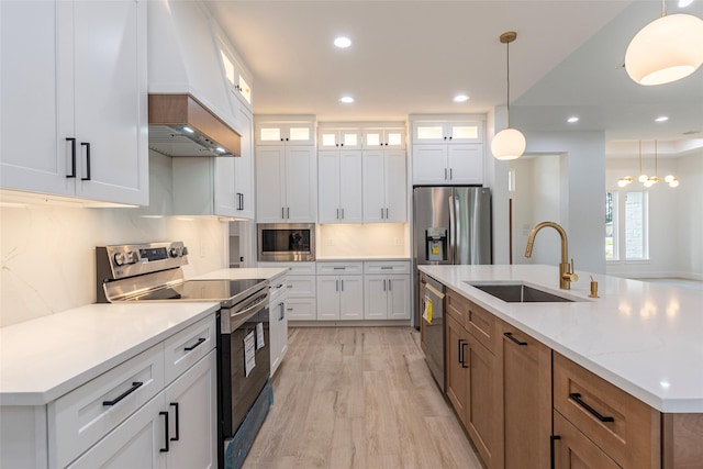 kitchen with white cabinets, appliances with stainless steel finishes, pendant lighting, and sink