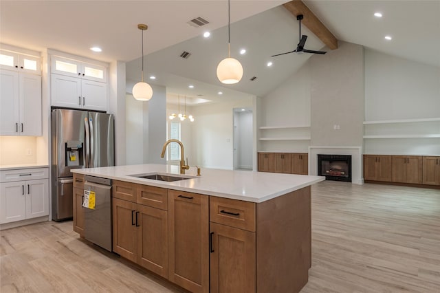 kitchen featuring hanging light fixtures, sink, white cabinets, and stainless steel appliances