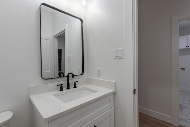 bathroom featuring vanity, hardwood / wood-style flooring, and toilet