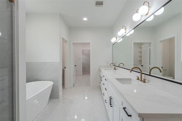 bathroom featuring vanity, a bathtub, and tile walls