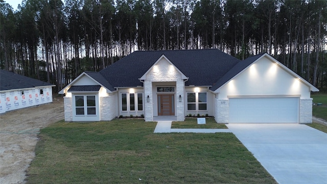 view of front of home with a front yard and a garage