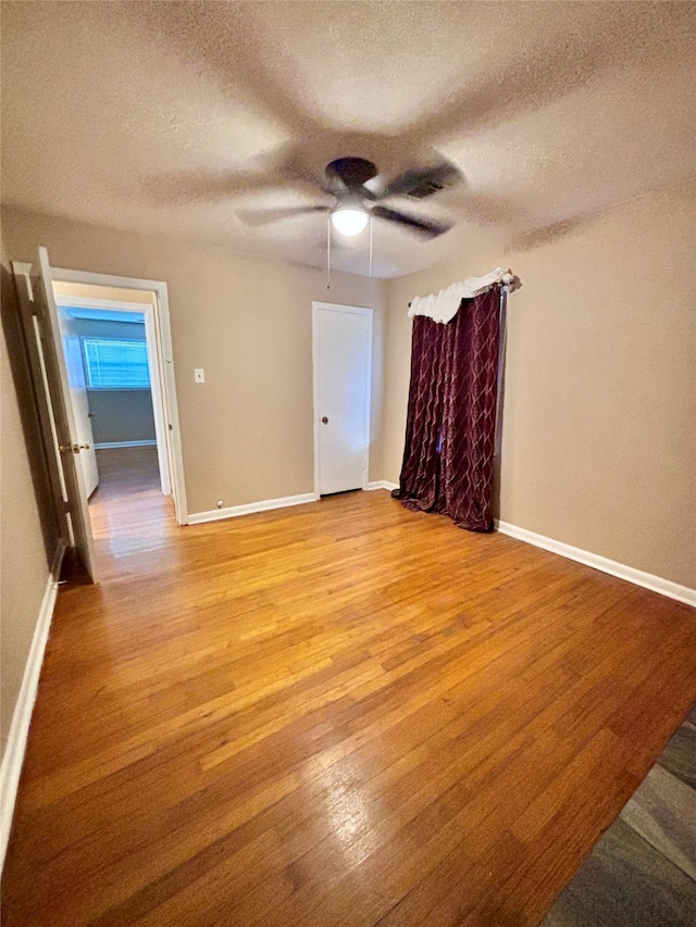 spare room with ceiling fan, a textured ceiling, and light hardwood / wood-style flooring