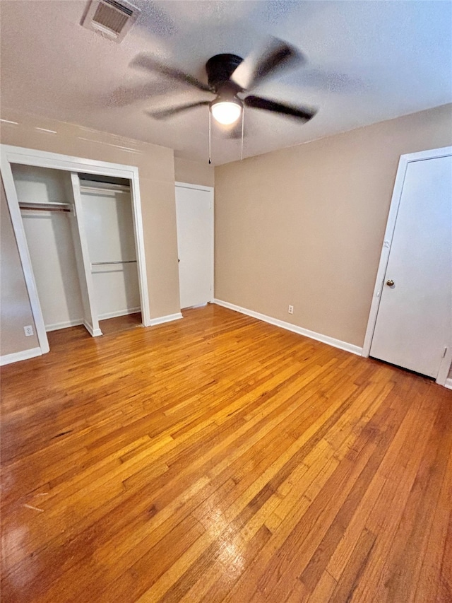 unfurnished bedroom featuring ceiling fan, light hardwood / wood-style flooring, and a textured ceiling