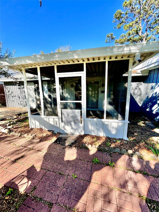 rear view of house featuring a sunroom