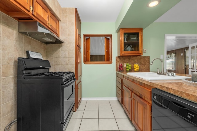 kitchen featuring tasteful backsplash, sink, light tile patterned floors, and black appliances