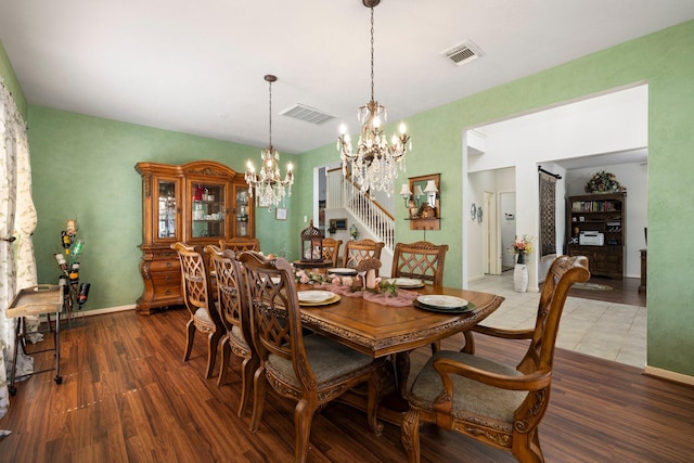 dining area with hardwood / wood-style flooring and a notable chandelier