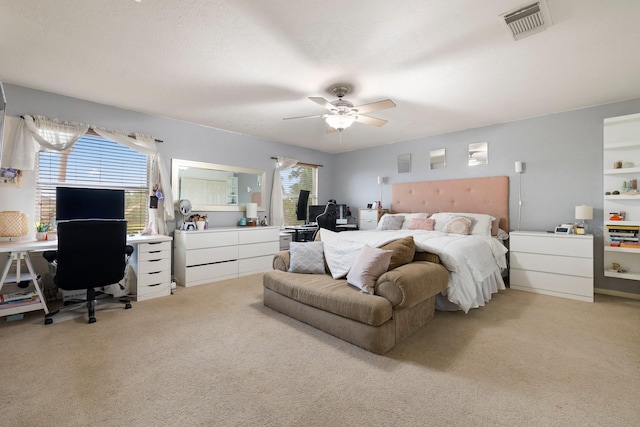 carpeted bedroom with multiple windows, ceiling fan, and a textured ceiling