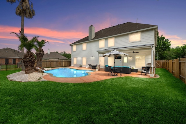 back house at dusk featuring a fenced in pool, an outdoor hangout area, ceiling fan, a yard, and a patio