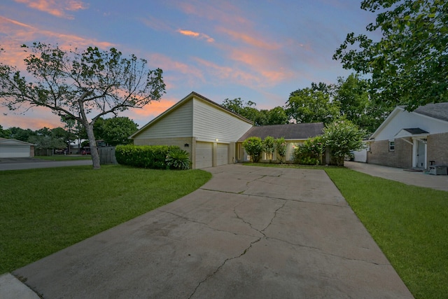 property exterior at dusk with a yard and a garage