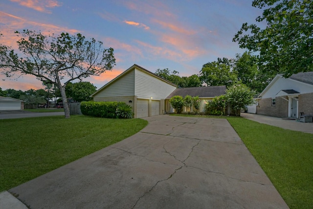 view of home's exterior with a garage, concrete driveway, brick siding, and a lawn