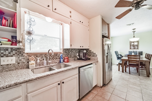 kitchen featuring decorative backsplash, stainless steel appliances, sink, decorative light fixtures, and light tile patterned flooring