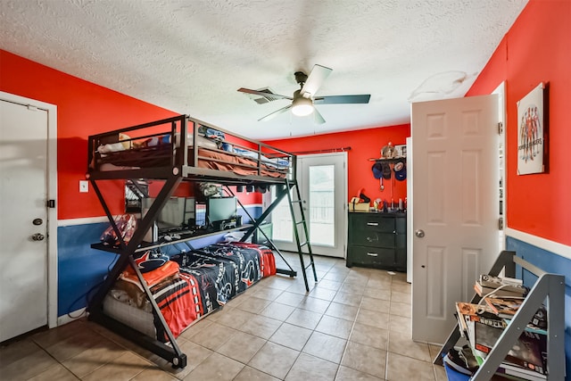 tiled bedroom with a textured ceiling and ceiling fan