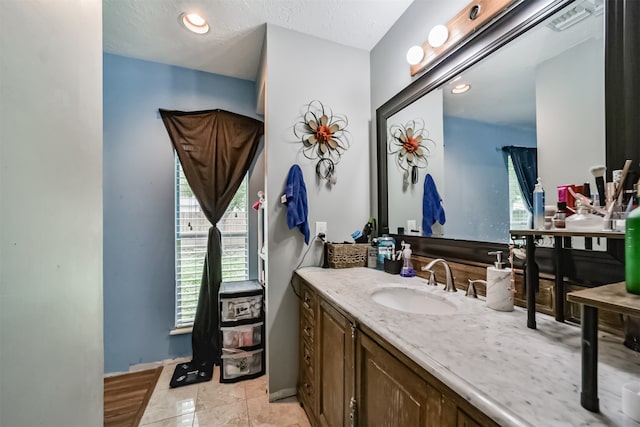 bathroom featuring tile patterned floors, vanity, and a textured ceiling